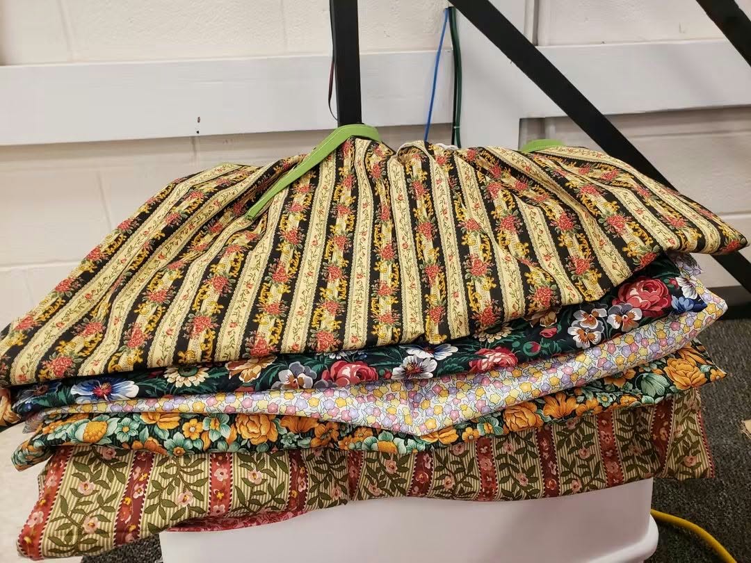 A stack of finished handmade dresses ready to be sent to girls around the world